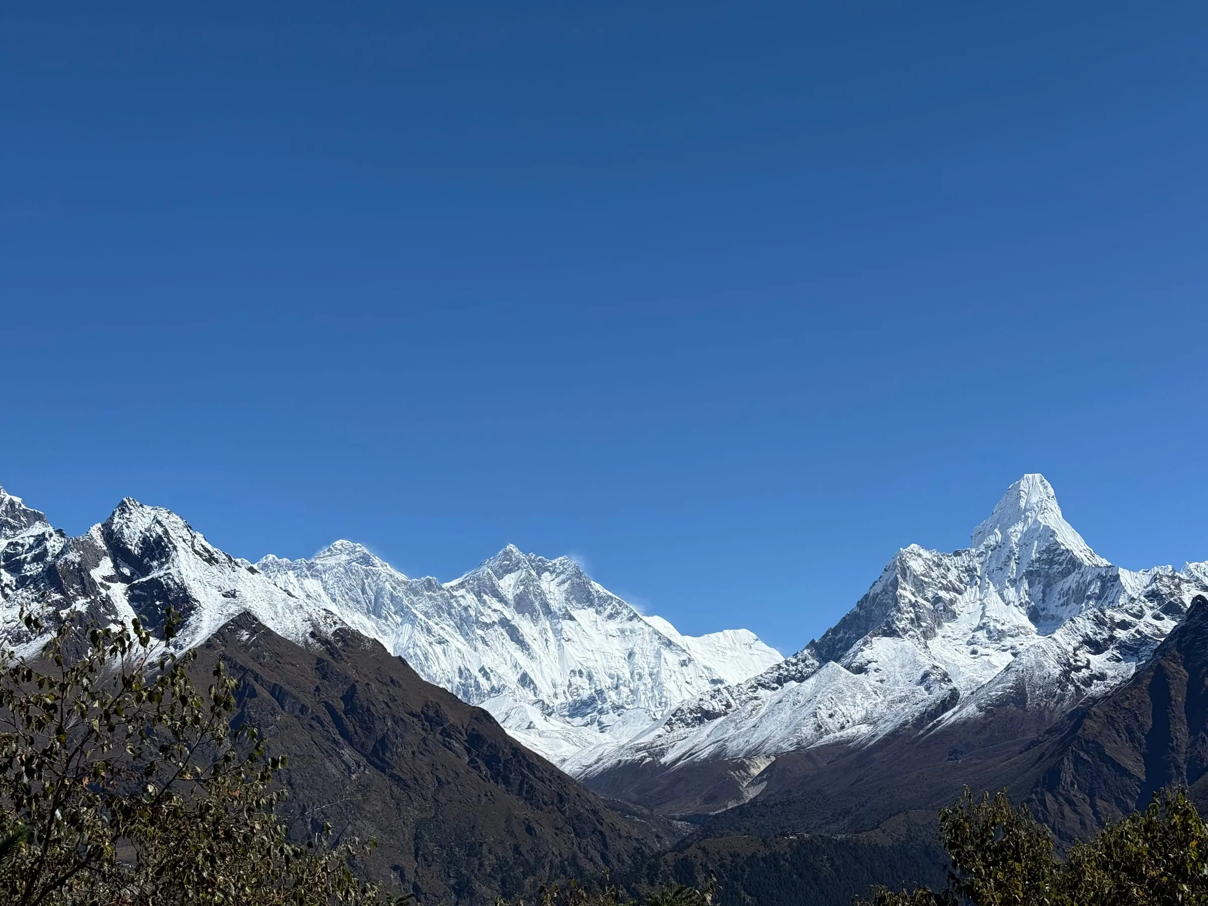 Everest and Lhotse behind a long ridge with Ama Dablam to the right, seen from the trail towards Everest Base Camp.